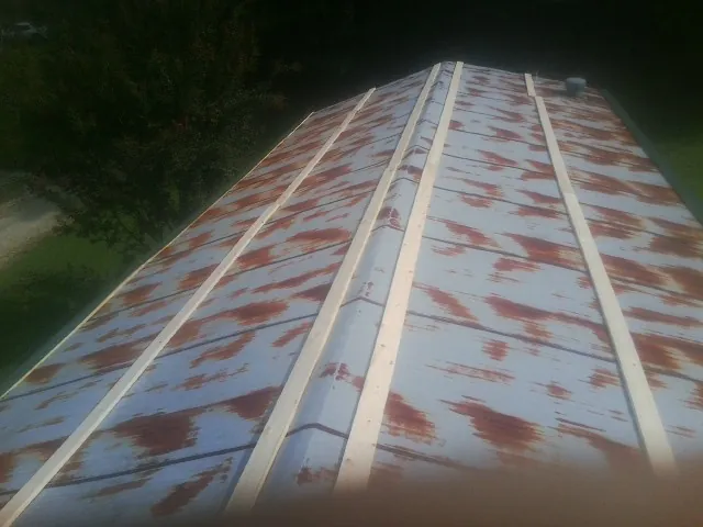 Rusted metal roof panels with new wood purlins before replacement — Storm Damage Roof Repair in Wyoming by Roofing Brothers